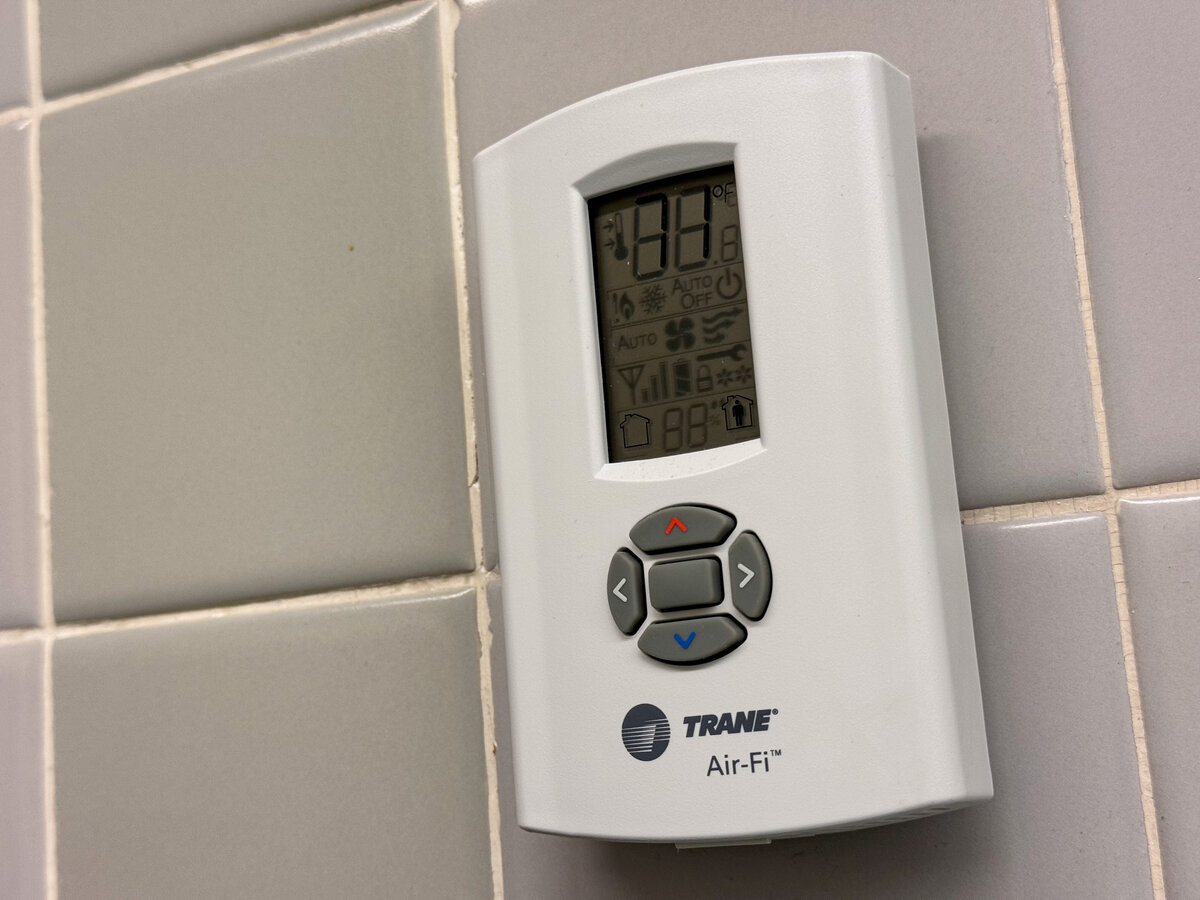 Residential Trane Air-Fi thermostat on a tiled wall